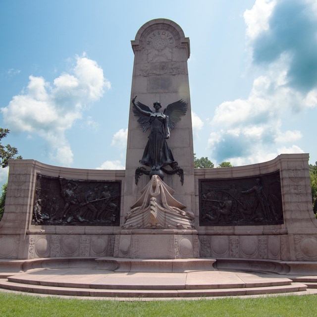 A large monument in the battlefield in dayight