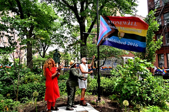 Artist Miss Simone, National Park Service Superintendent Shirley McKinny, and LGBTQ+ activist Steven Love Menendez raise the Progress flag at Christopher Park. The ceremony also included a land acknowledgement from Janis Stacey and speeche